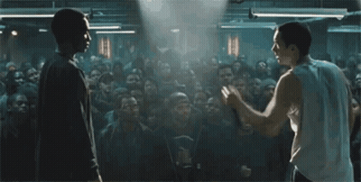 Two Men Are Standing In Front Of A Crowd Of People . GIF