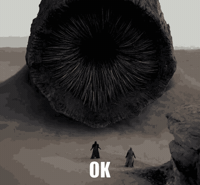 Two Men Are Standing In Front Of A Large Object That Says Ok On The Bottom GIF