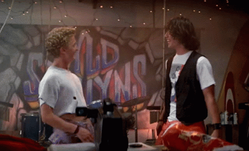 Two Men Are Standing In Front Of A Mural That Says Old Lynns GIF