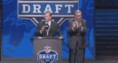 Two Men Are Standing In Front Of A Podium That Says Draft GIF