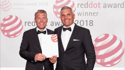 Two Men Are Standing In Front Of A Red Dot Award 2018 Background GIF