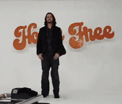 Two Men Are Standing In Front Of A Sign That Says " Ho Free " GIF