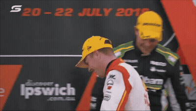 Two Men Are Standing In Front Of A Sign That Says Ipswich On It GIF