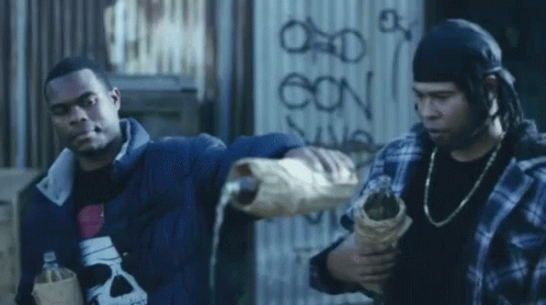 Two Men Are Standing In Front Of A Wall That Has The Letters Oon On It GIF