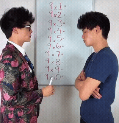 Two Men Are Standing In Front Of A Whiteboard With Numbers On It GIF