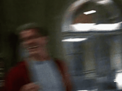 Two Men Are Standing Next To Each Other And Laughing In A Room . GIF