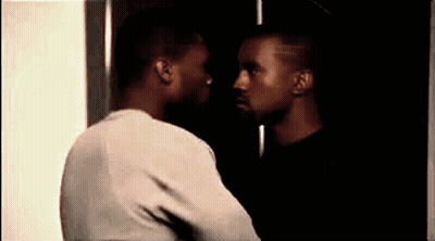 Two Men Are Standing Next To Each Other And Looking At Each Other In A Dark Room . GIF