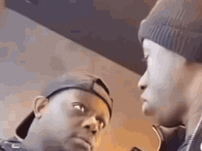 Two Men Are Standing Next To Each Other And Looking At Each Other . One Of The Men Is Wearing A Beanie . GIF