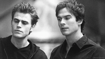 Two Men Are Standing Next To Each Other And Looking At Each Other . GIF