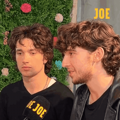 Two Men Are Standing Next To Each Other And One Has A Microphone With The Word Joe On It GIF