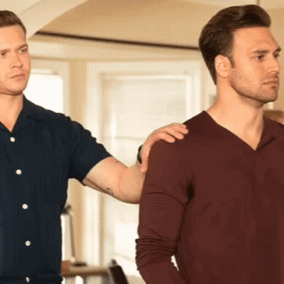 Two Men Are Standing Next To Each Other And One Has His Hand On The Shoulder Of The Other . GIF