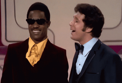 Two Men Are Standing Next To Each Other And One Has Sunglasses On GIF