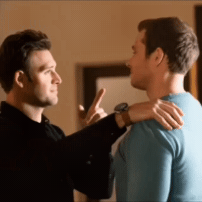 Two Men Are Standing Next To Each Other And One Man Is Pointing At The Other . GIF