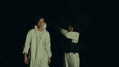 Two Men Are Standing Next To Each Other And One Of Them Has A Nike Necklace Around His Neck GIF