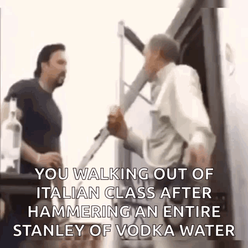 Two Men Are Standing Next To Each Other And One Of Them Is Holding A Bottle Of Vodka . GIF