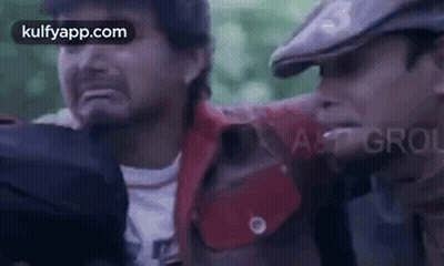 Two Men Are Standing Next To Each Other And One Of Them Is Holding Another Man 'S Hand . GIF