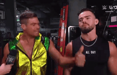 Two Men Are Standing Next To Each Other And One Of Them Is Wearing A Black Tank Top That Says All Day GIF