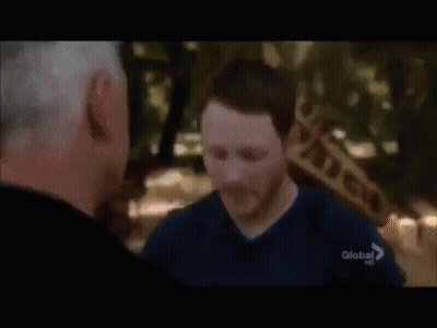 Two Men Are Standing Next To Each Other And One Of Them Is Wearing A Blue Shirt With The Word Global On It . GIF
