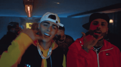 Two Men Are Standing Next To Each Other And One Of Them Is Wearing A Red Tommy Hilfiger Jacket GIF