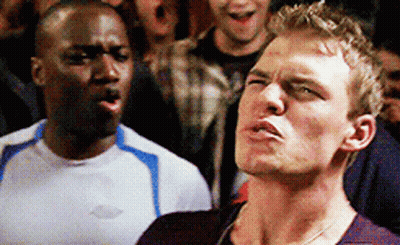 Two Men Are Standing Next To Each Other And One Of Them Is Wearing A Shirt With The Word Chevrolet On It GIF