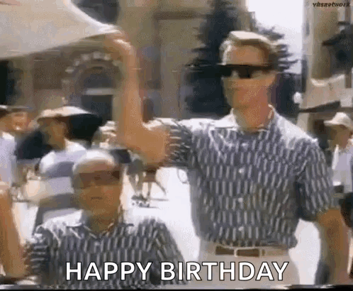 Two Men Are Standing Next To Each Other And One Of Them Is Wearing Sunglasses And A Happy Birthday Sign . GIF