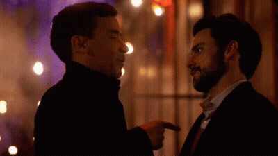 Two Men Are Standing Next To Each Other And Pointing At Each Other GIF