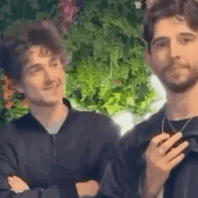 Two Men Are Standing Next To Each Other And Smiling . GIF