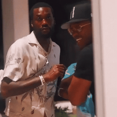 Two Men Are Standing Next To Each Other And Talking . One Of The Men Is Wearing A Hat . GIF