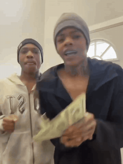 Two Men Are Standing Next To Each Other Holding A Large Amount Of Money . GIF