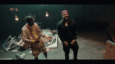 Two Men Are Standing Next To Each Other In A Dark Room . GIF