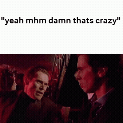 Two Men Are Standing Next To Each Other In A Dark Room Talking To Each Other . GIF