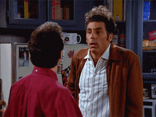 Two Men Are Standing Next To Each Other In A Kitchen And One Of Them Is Wearing A Brown Jacket That Says Lipton On It GIF