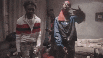Two Men Are Standing Next To Each Other In A Living Room And Making A Peace Sign . GIF