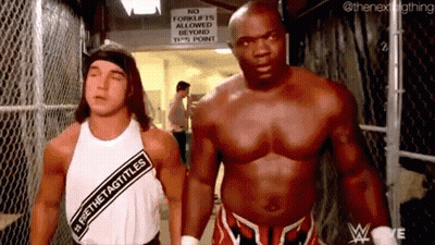 Two Men Are Standing Next To Each Other In A Locker Room . GIF