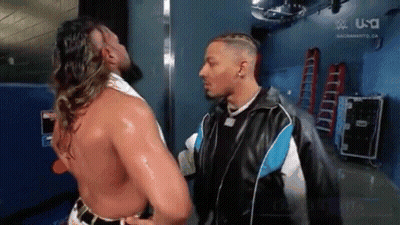 Two Men Are Standing Next To Each Other In A Locker Room . GIF