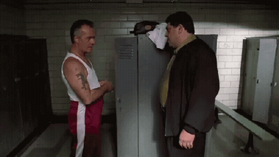Two Men Are Standing Next To Each Other In A Locker Room Talking . GIF