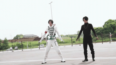 Two Men Are Standing Next To Each Other In A Parking Lot GIF
