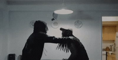 Two Men Are Standing Next To Each Other In A Room And Fighting . GIF