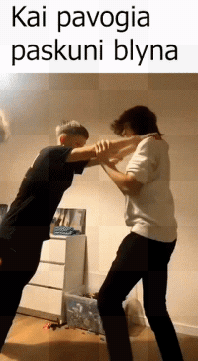 two men are standing next to each other in a room and fighting each other .