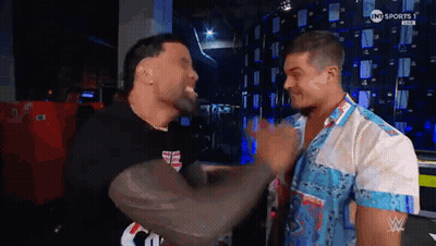 Two Men Are Standing Next To Each Other In A Room And Having A Conversation . GIF