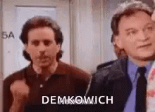 Two Men Are Standing Next To Each Other In A Room . One Of The Men Is Wearing A Tie . GIF