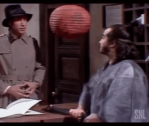Two Men Are Standing Next To Each Other In A Room Talking To Each Other . GIF