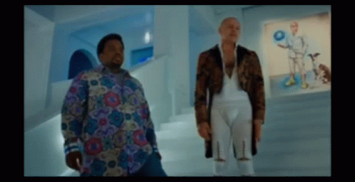 Two Men Are Standing Next To Each Other In A Room With Pictures On The Wall GIF
