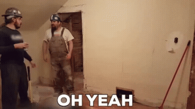 Two Men Are Standing Next To Each Other In A Room With The Words `` Oh Yeah '' On The Wall . GIF