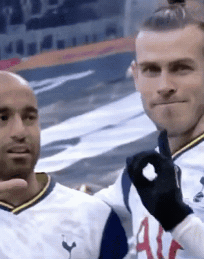 Two Men Are Standing Next To Each Other In A Stadium And One Of Them Is Wearing A Black Glove . GIF