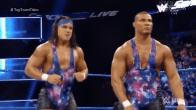 Two Men Are Standing Next To Each Other In A Wrestling Ring Wearing Floral Tank Tops . GIF