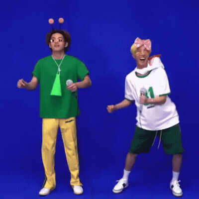 Two Men Are Standing Next To Each Other In Front Of A Blue Background And Holding Microphones . GIF