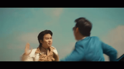Two Men Are Standing Next To Each Other In Front Of A Blue Sky And Giving Each Other A High Five . GIF