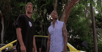 Two Men Are Standing Next To Each Other In Front Of A Car GIF