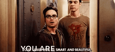 Two Men Are Standing Next To Each Other In Front Of A Door . One Of The Men Is Wearing A Flash Shirt . GIF